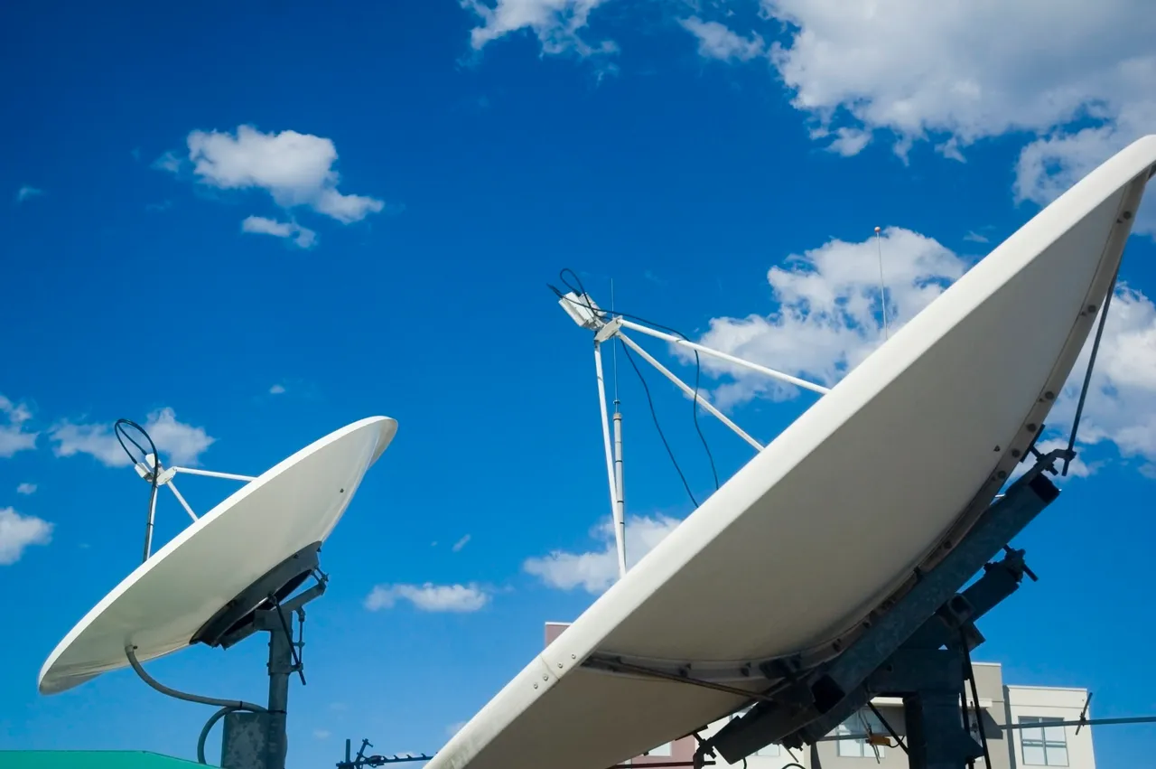 Twee schotelantennes voor communicatie tegen een blauwe lucht
