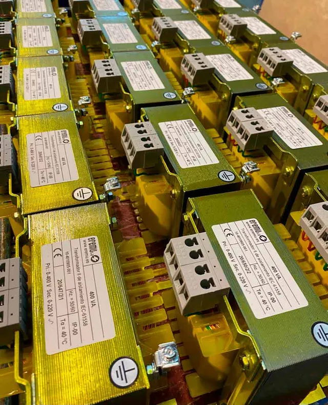 Scheidingstransformatoren van EREMU op een rij in de werkplaats, met hun typeplaatjes al gemonteerd.